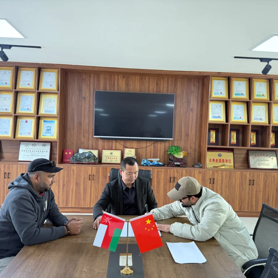 4U Business Links team signing with a supplier, Oman and China flags on the table